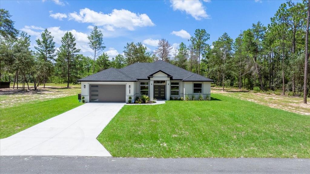 A single-story house with a gray garage and dark roof sits on a grassy lot — 4438 SW 179TH PLACE, OCALA, FL