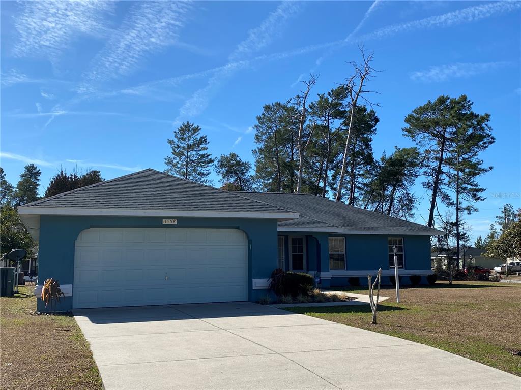 A blue single-story house with a two-car garage and a concrete driveway — 3658 SW 127TH LANE ROAD, OCALA, FL