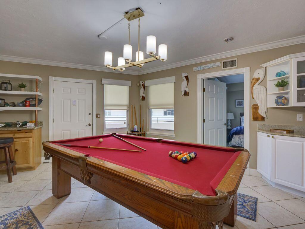 A game room features a red pool table, tile flooring, and a brass chandelier — 2055 S Atlantic Avenue # 1410, FL 32118, FL