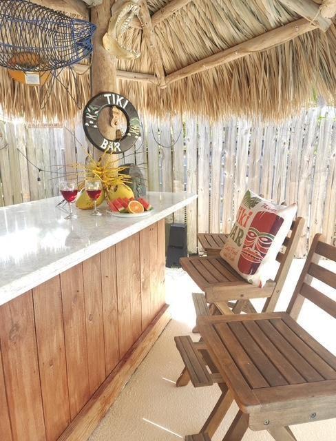 An outdoor tiki bar features a thatched roof, wooden stools, and a stone-topped counter — 309 E Calzada De Bougainville, Marathon FL 33050, MARATHON, FL