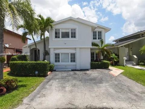 A two-story white house with a paved driveway and palm trees in the front yard — 933 NW 106th Ave Cir, Miami FL 33172, MIAMI, FL