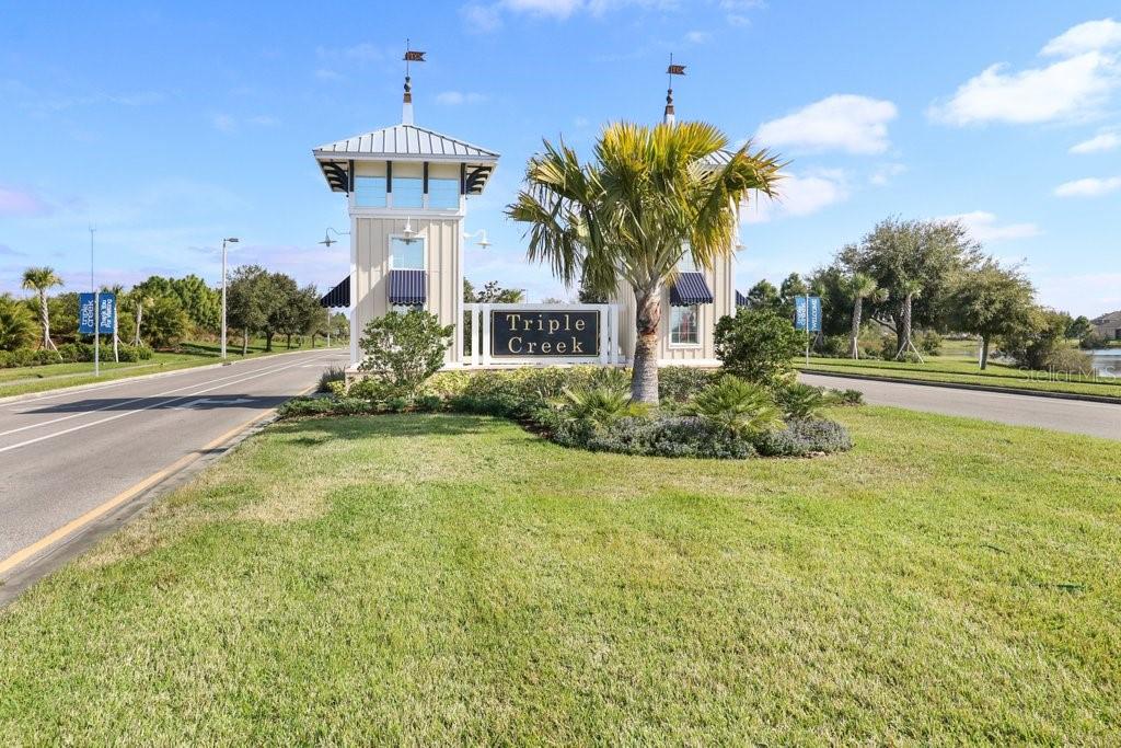 The entrance to the Triple Creek community features two towers and a central sign — 13117 ROYAL PINES AVENUE, RIVERVIEW, FL