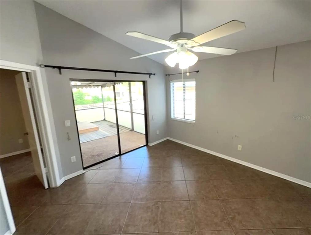 A room with gray walls, tile flooring, a ceiling fan, and sliding glass doors — 2201 GRASMERE DRIVE, APOPKA, FL