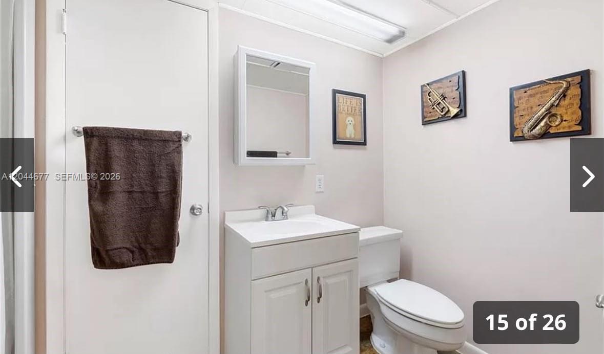 A bathroom features a white vanity, a medicine cabinet, a toilet, and musical instrument wall art — 4210 CINDY, Naples FL 34112, NAPLES, FL