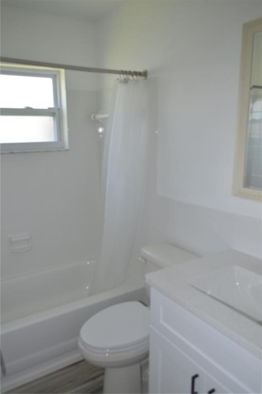 A bathroom features a white vanity, a toilet, and a shower-tub combination with a window — 3708 97TH AVENUE N, PINELLAS PARK, FL