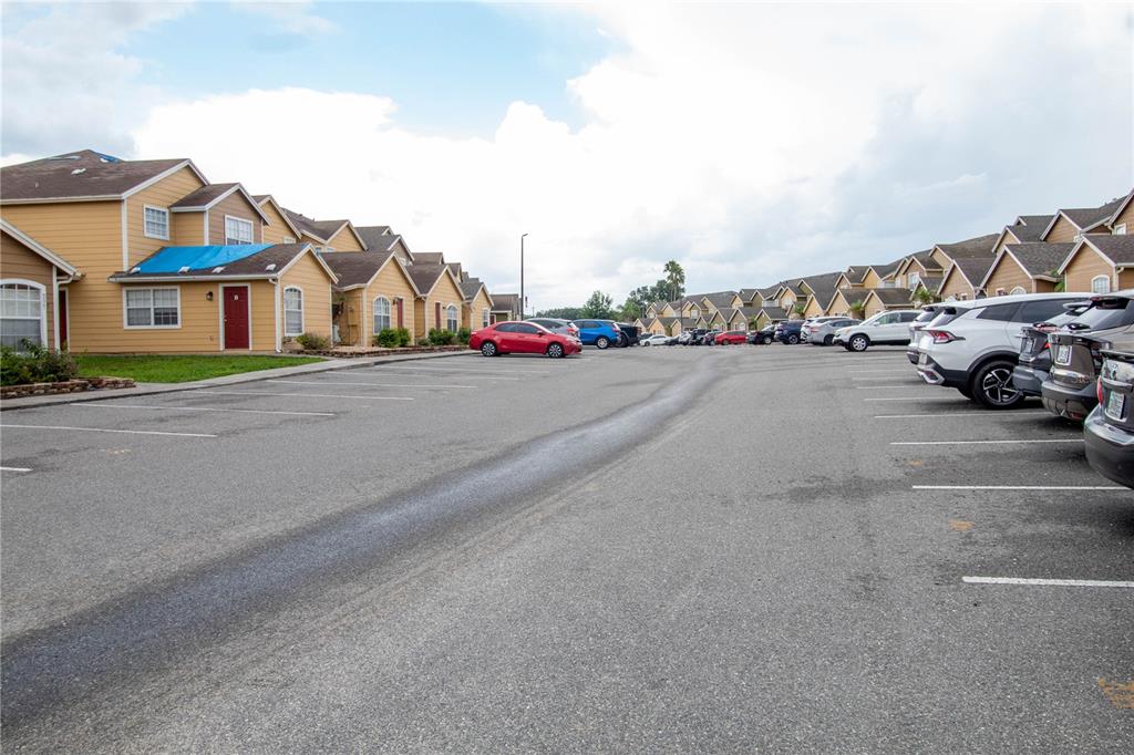 An exterior view of a multi-unit residential complex with a large parking lot — 217 AUSTRALIAN WAY UNIT A, DAVENPORT, FL