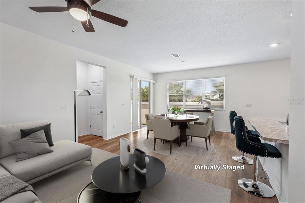A bright living room features wood-look flooring, a ceiling fan, and a breakfast bar — 2896 89TH STREET CIRCLE E, PALMETTO, FL