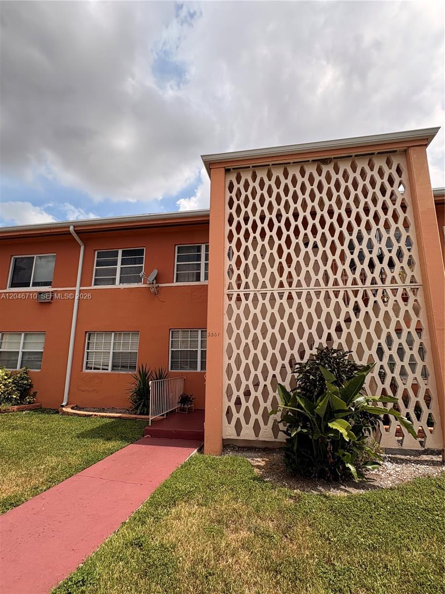 A two-story orange apartment building features a decorative white lattice screen over the stairwell — 3501 SW 10th St # 1B, Miami FL 33135, MIAMI, FL