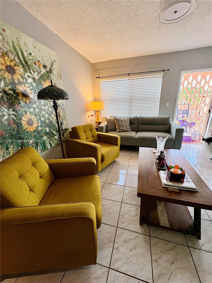 A living room features two yellow armchairs, a grey sofa, and a wooden coffee table — 3501 SW 10th St # 1B, Miami FL 33135, MIAMI, FL