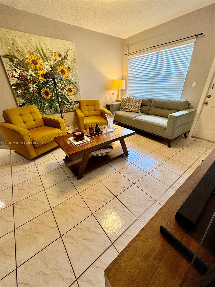 A living room features two yellow armchairs, a gray sofa, and a wooden coffee table — 3501 SW 10th St # 1B, Miami FL 33135, MIAMI, FL