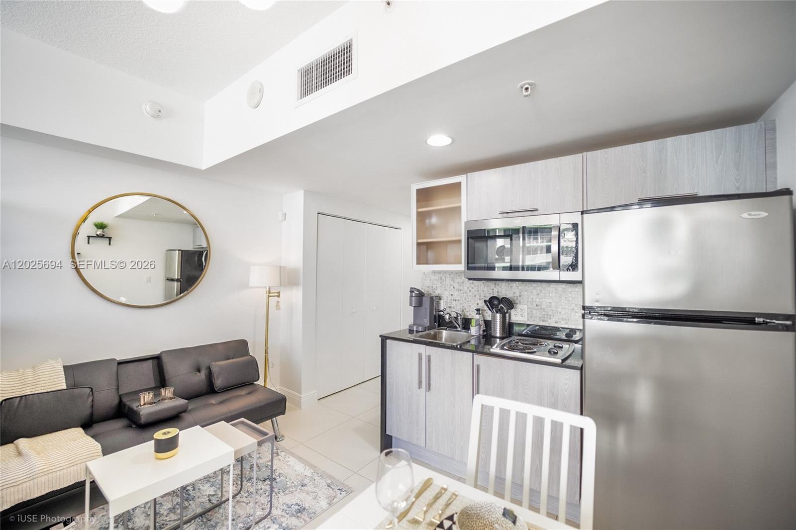A small apartment features a kitchen with stainless steel appliances next to a living area — 1750 N Bayshore Dr # 1219, Miami FL 33132, MIAMI, FL