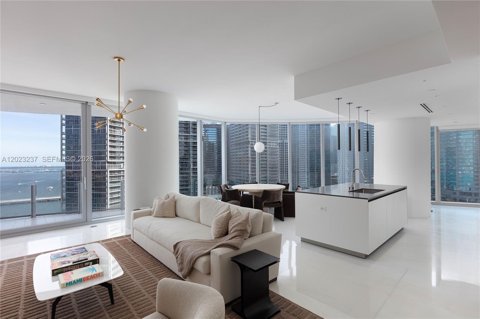 A modern open-concept living room and kitchen feature floor-to-ceiling windows with city and water views — 300 S Biscayne Blvd Way # 2107, Miami FL 33131, MIAMI, FL