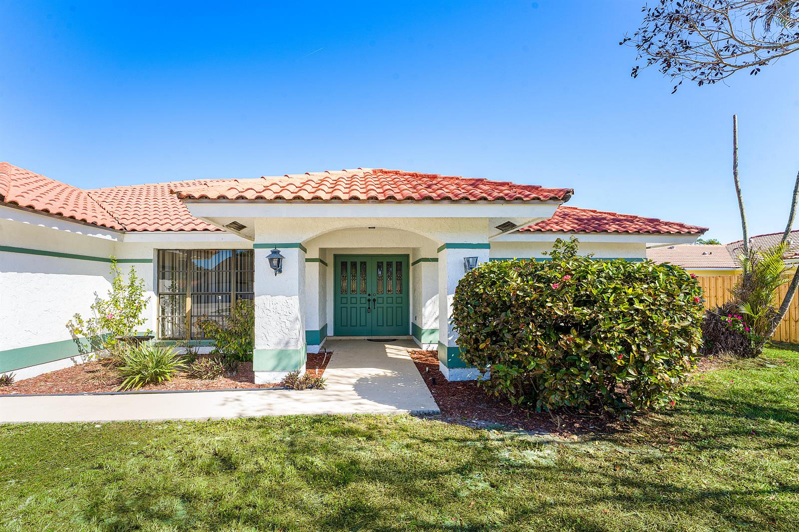 A single-story house with a terracotta tile roof and green double front doors — 2057 Amesbury Circle, Wellington FL 33414, WELLINGTON, FL