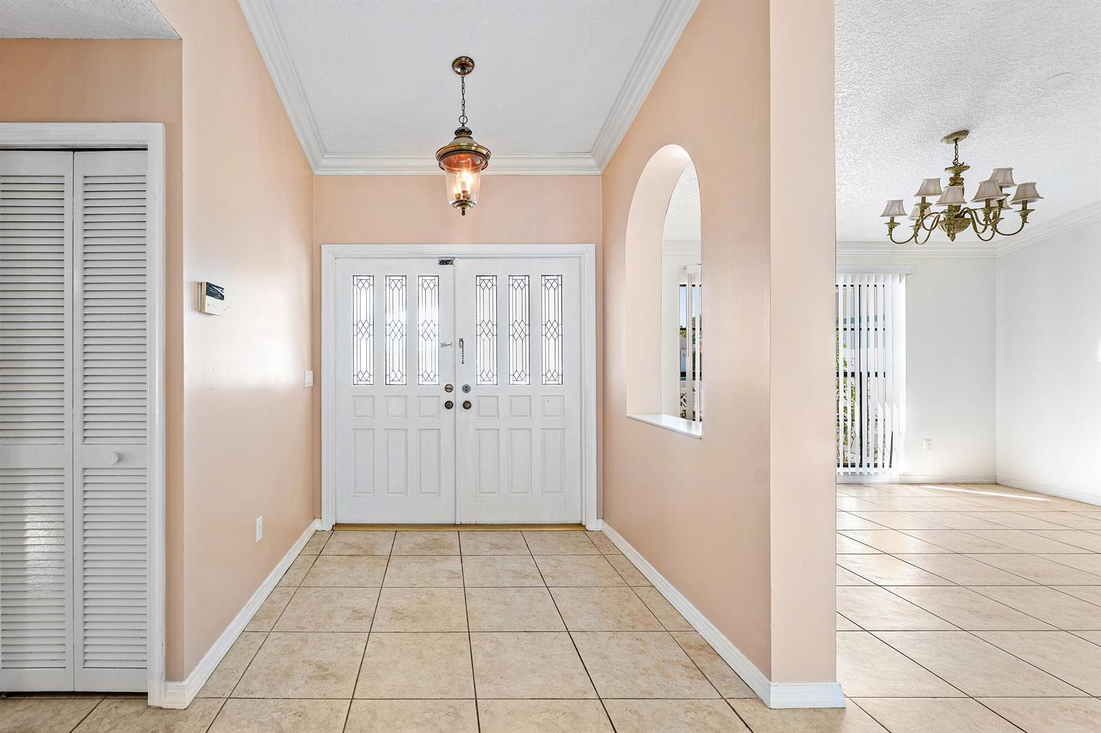 An entryway with tiled floors, a white double door, and a wall cutout to a room — 2057 Amesbury Circle, Wellington FL 33414, WELLINGTON, FL
