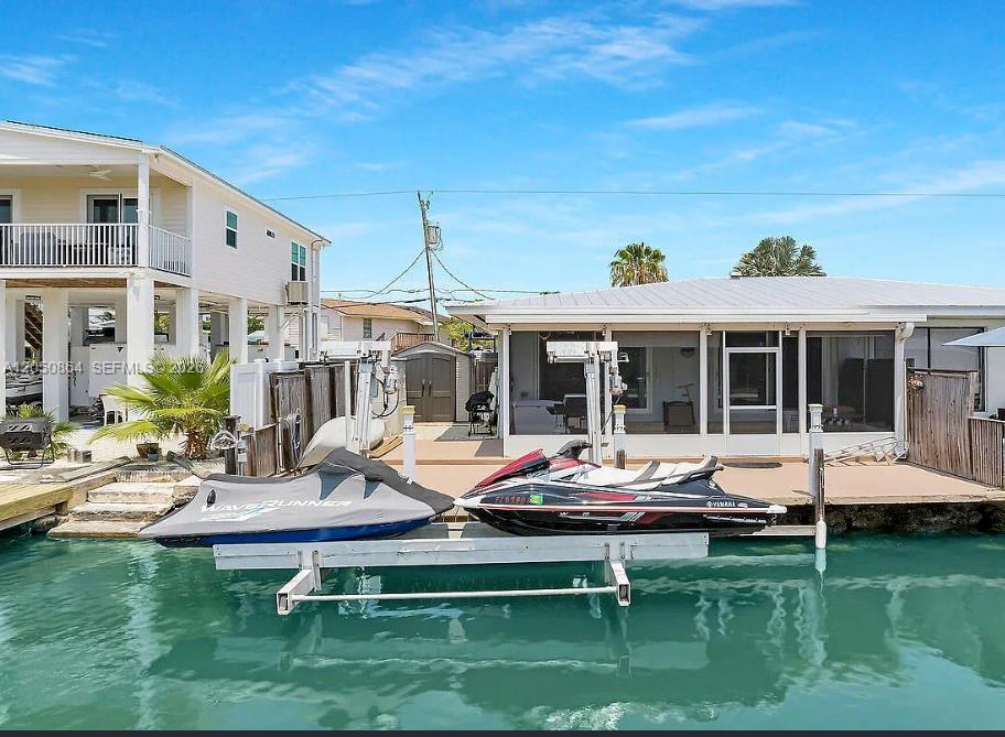 Two jet skis are parked on a boat lift in front of a waterfront house — 425 89th Street Ocean, Marathon FL 33050, MARATHON, FL