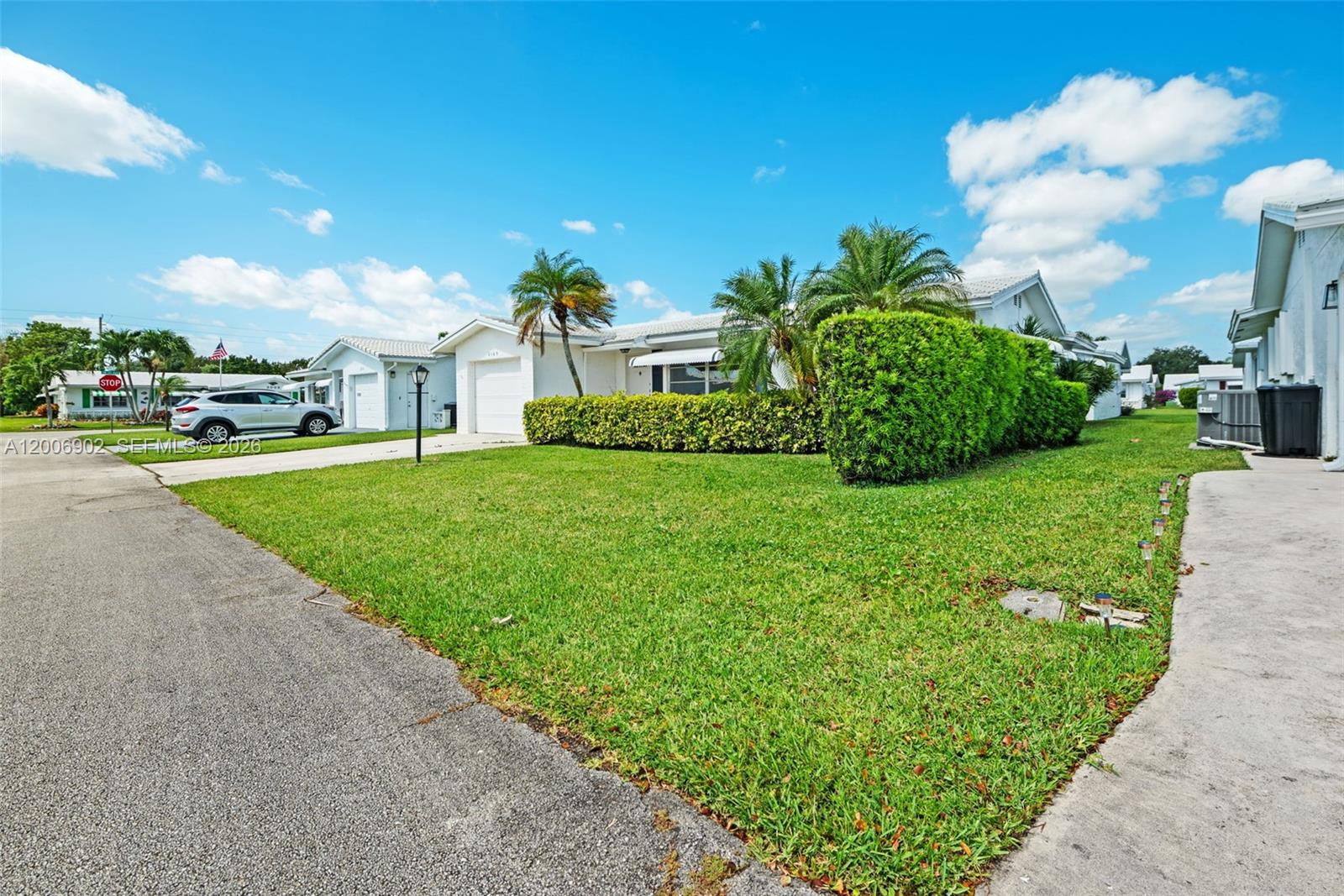 A single-story house with a white exterior, a green lawn, and a manicured hedge — 2103 SW 20th Cir, Boynton Beach FL 33426, BOYNTON BEACH, FL