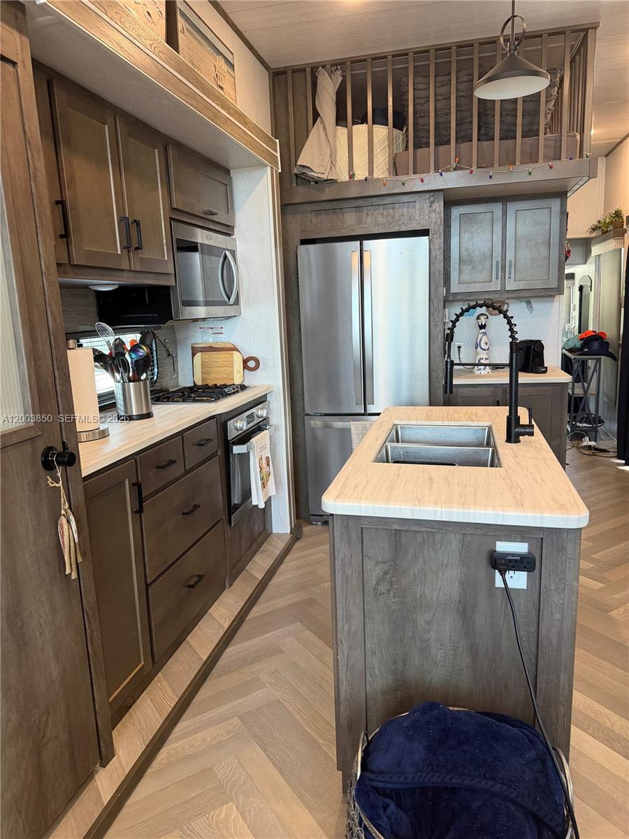 A kitchen features dark wood cabinetry, stainless steel appliances, a center island, and a loft — 325 Calusa St Lot 345, Key Largo FL 33037, KEY LARGO, FL