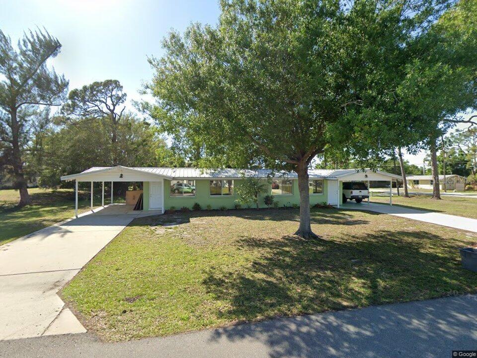 An aerial view shows a residential neighborhood with houses, trees, and a distant body of water — 50 S NEW YORK AVENUE UNIT 2, ENGLEWOOD, FL