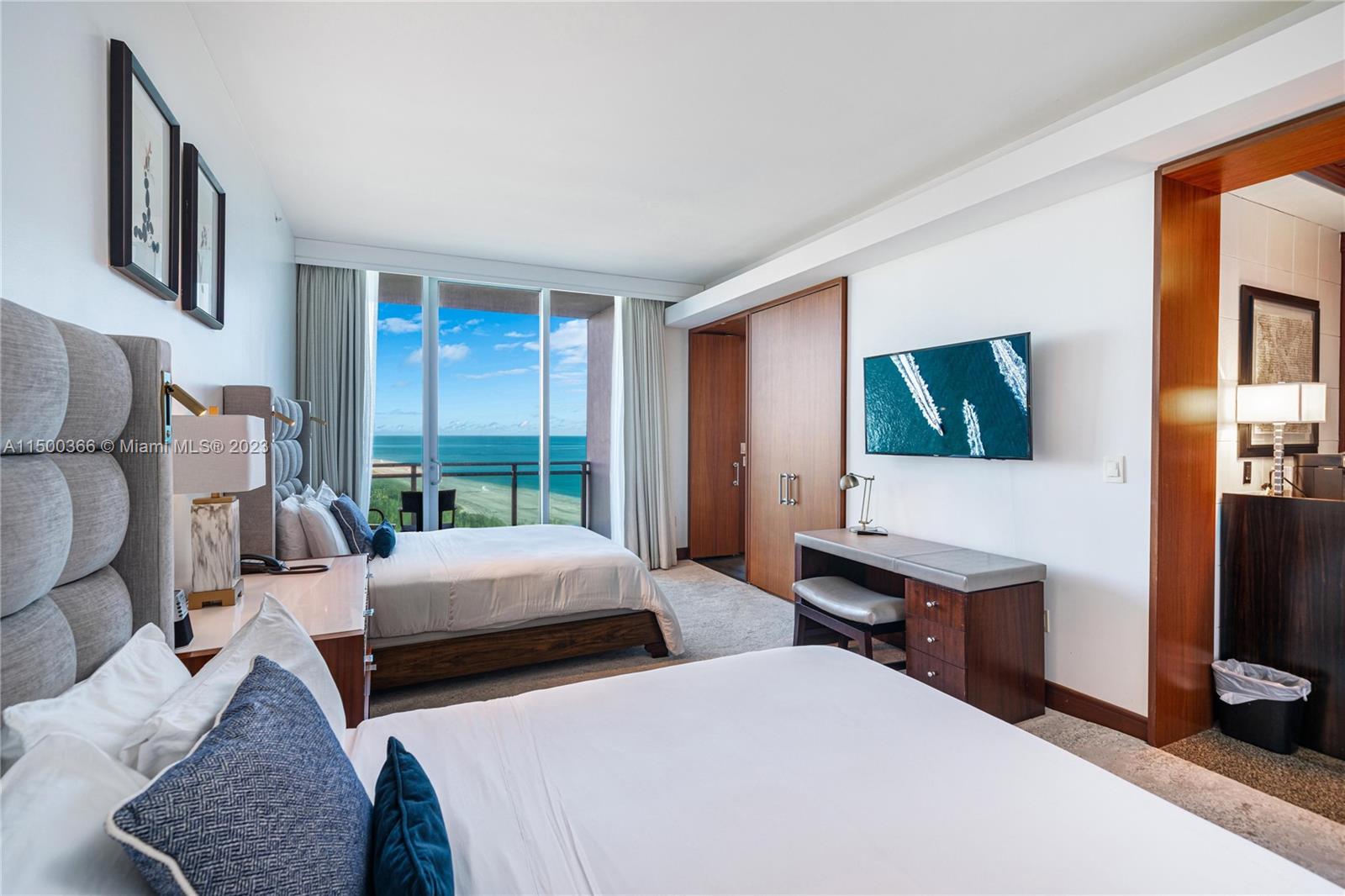 A hotel room features two beds, a desk, a wall-mounted television, and a balcony view — 10295 Collins Ave # 1216, Bal Harbour FL 33154, BAL HARBOUR, FL