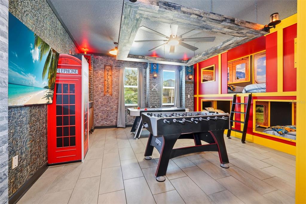 A game room features a foosball table, air hockey table, bunk beds, and a telephone booth — 690 DROP SHOT DRIVE, DAVENPORT, FL