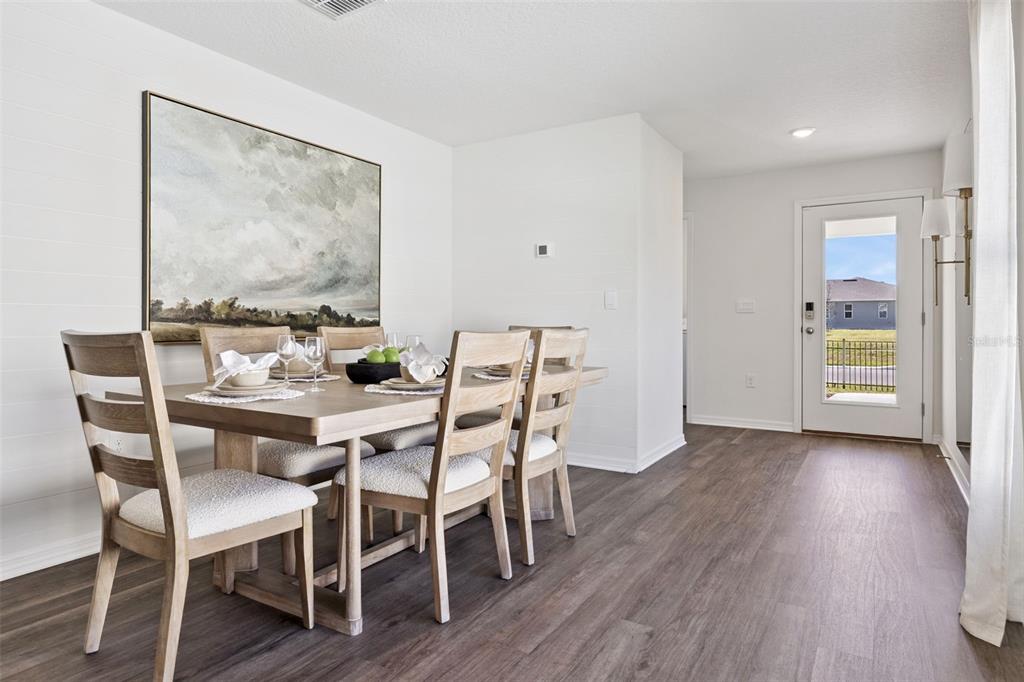 A dining area features a wooden table with chairs, shiplap walls, and a glass door — 3999 LIMEKLIN FALLS LOOP, DAVENPORT, FL