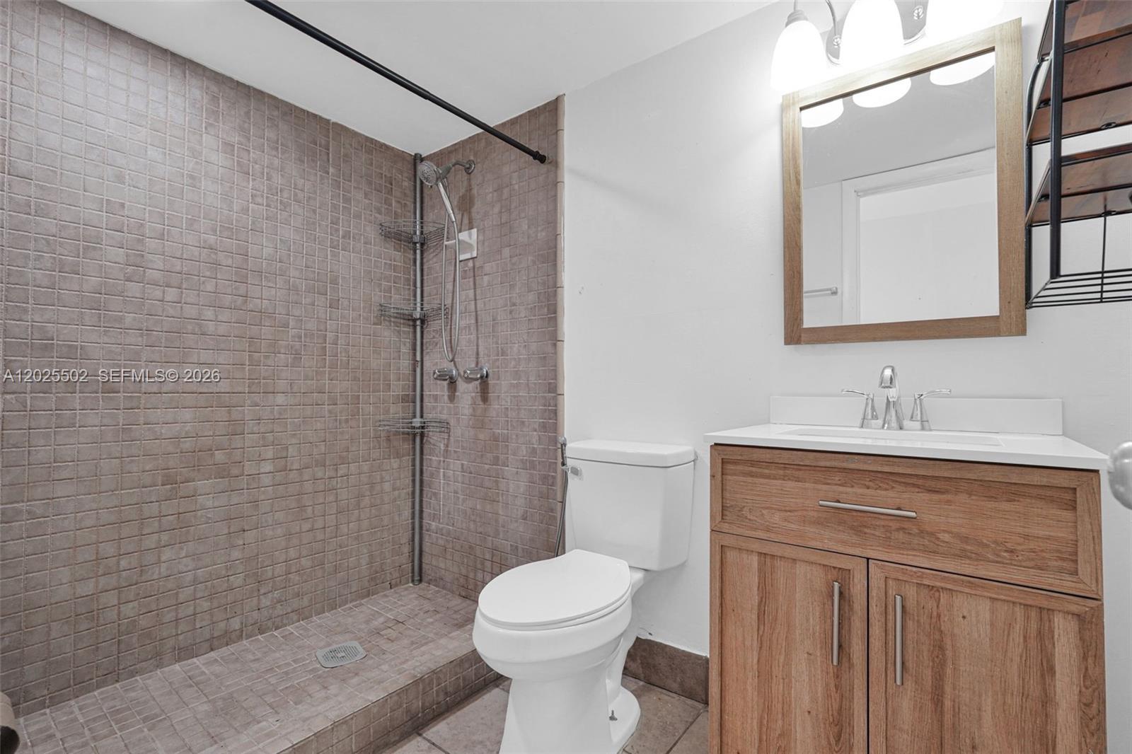 A bathroom features a tiled walk-in shower, a white toilet, and a wood vanity — 14500 NE 2nd Ave # 2, Miami FL 33161, MIAMI, FL