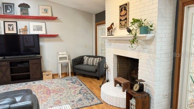 A living room features a white brick fireplace, a television on a wooden console, and shelving — 1990 LARCHMONT DRIVE, DELAND, FL