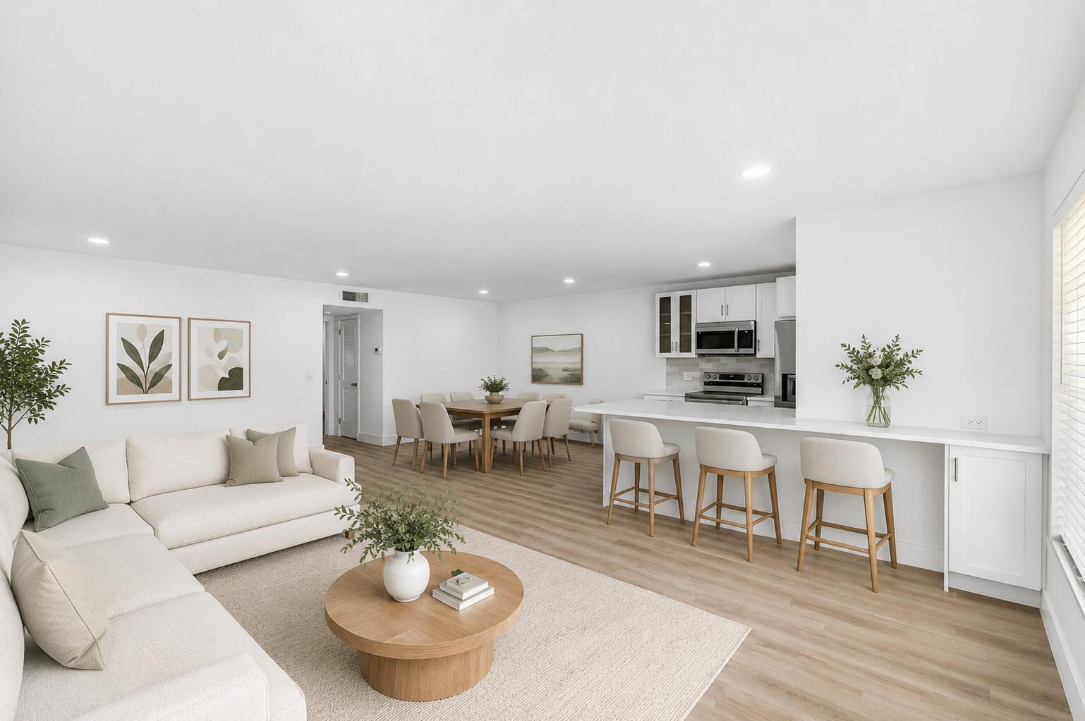 An open-concept living and dining area features white walls, light wood flooring, and modern furniture — 1007 South Drive, Delray Beach FL 33445, DELRAY BEACH, FL
