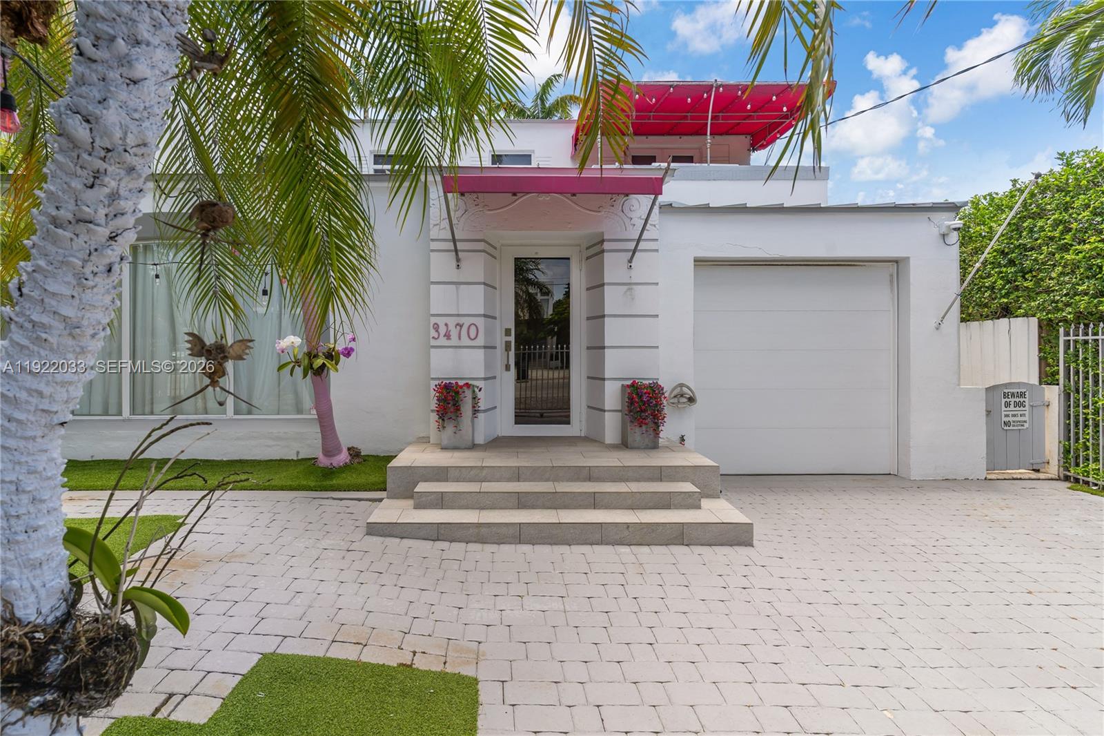 A white house with a pink awning, a front door, and a single-car garage — 3470 Sheridan Ave, Miami Beach FL 33140, MIAMI BEACH, FL