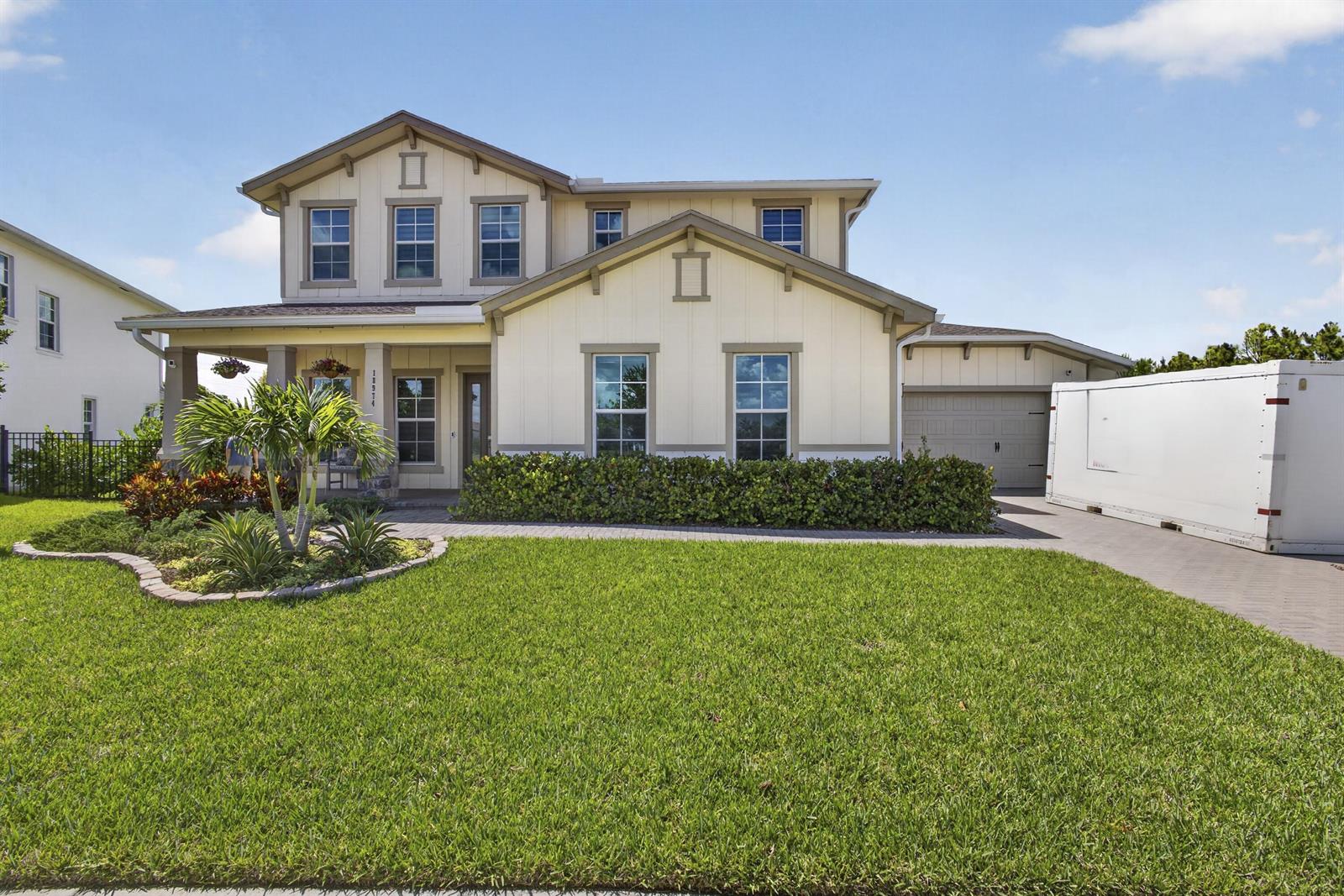 A two-story house with light yellow siding, a front porch, and a large white trailer — 18974 Tackle Box Trail, Loxahatchee FL 33470, LOXAHATCHEE, FL