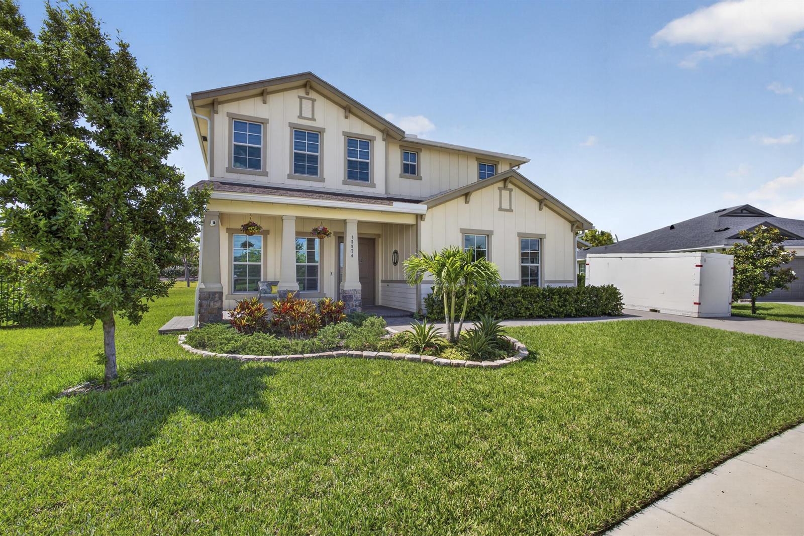 A two-story house with light-colored siding, a front porch, and a landscaped yard — 18974 Tackle Box Trail, Loxahatchee FL 33470, LOXAHATCHEE, FL