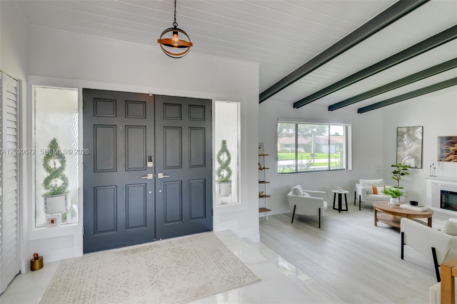 A bright entryway features a dark double door, white flooring, and exposed ceiling beams — 9340 NW 32nd St, Sunrise FL 33351, SUNRISE, FL