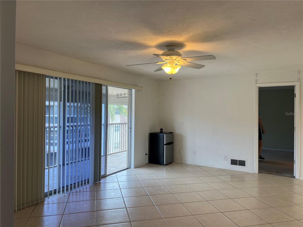 A living room with tile flooring, a ceiling fan, and a sliding glass door — 3751 S SCHOOL AVENUE UNIT 29, SARASOTA, FL