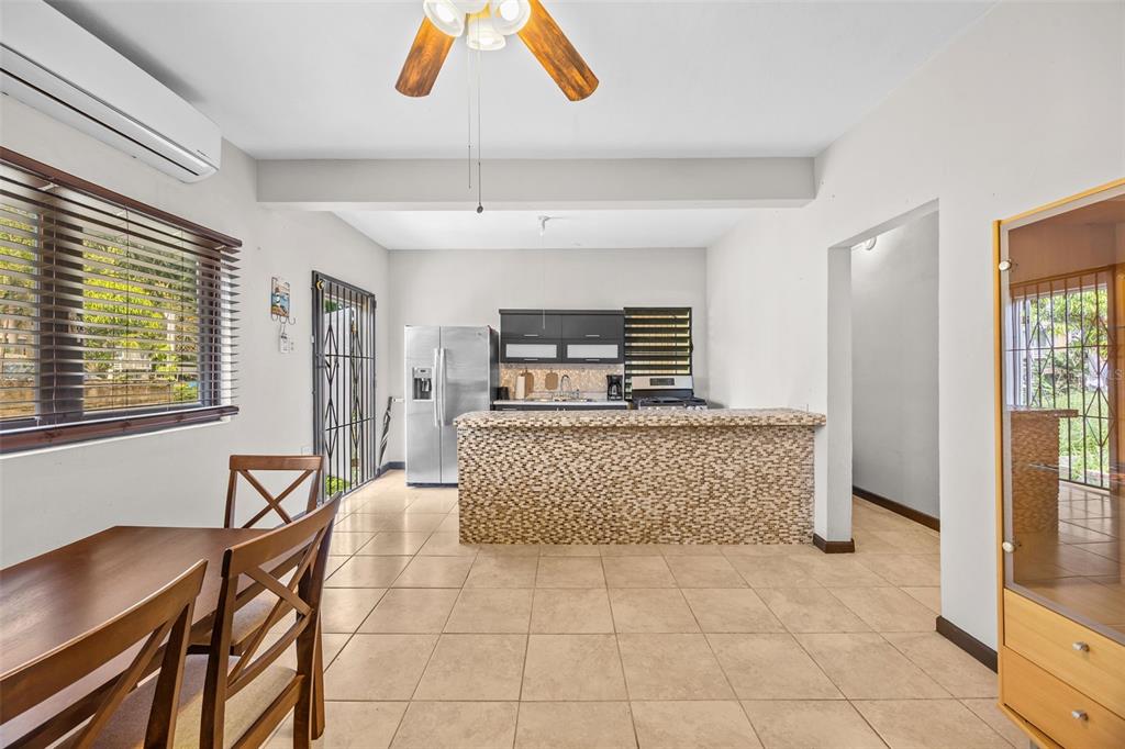 A kitchen with a tiled breakfast bar, stainless steel refrigerator, and dining area — BO Rio Hondo SOLAR 6, PR, PUERTO RICO,00680, MAYAGUEZ, PR