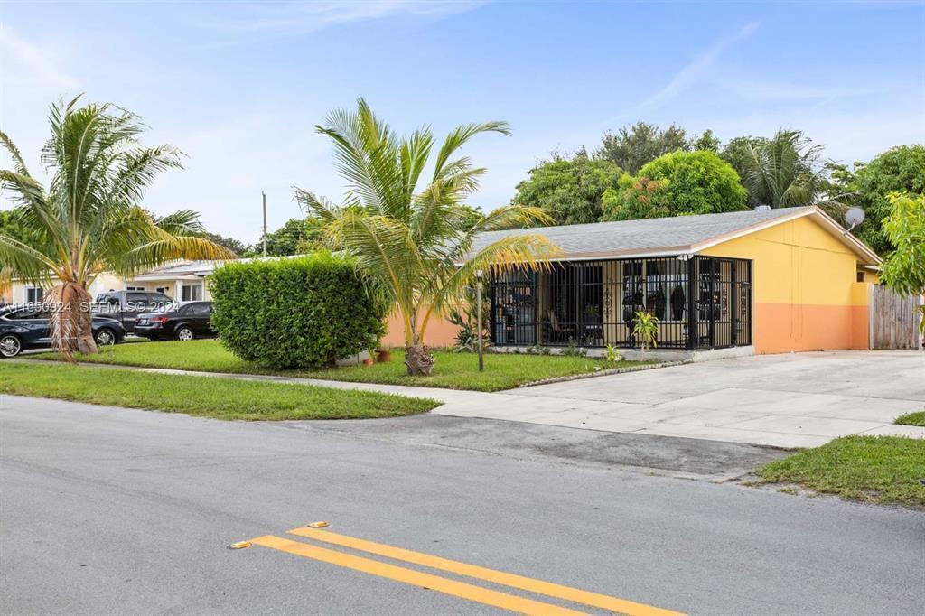 A single-story yellow house with a gated front porch and a palm tree in front — 18930 NW 14th Avenue, Miami FL 33169, MIAMI, FL