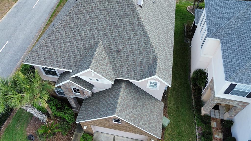 An aerial view shows the shingled roof and exterior of a suburban house with a garage — 2834 EAGLE EYE COURT, KISSIMMEE, FL