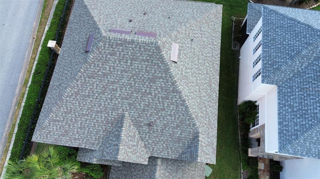 An aerial view shows the shingled roofs of two adjacent houses and a side yard — 2834 EAGLE EYE COURT, KISSIMMEE, FL