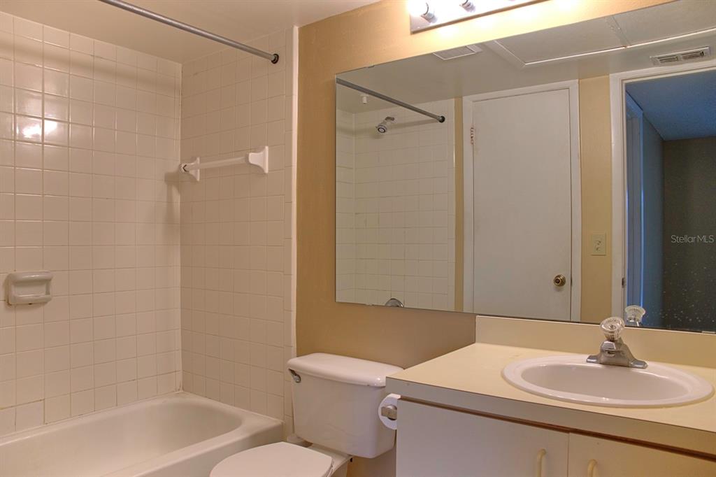 A bathroom features a white vanity, a toilet, and a shower-tub combination with white tiles — 351 LONE HILL DRIVE UNIT 306, ALTAMONTE SPRINGS, FL