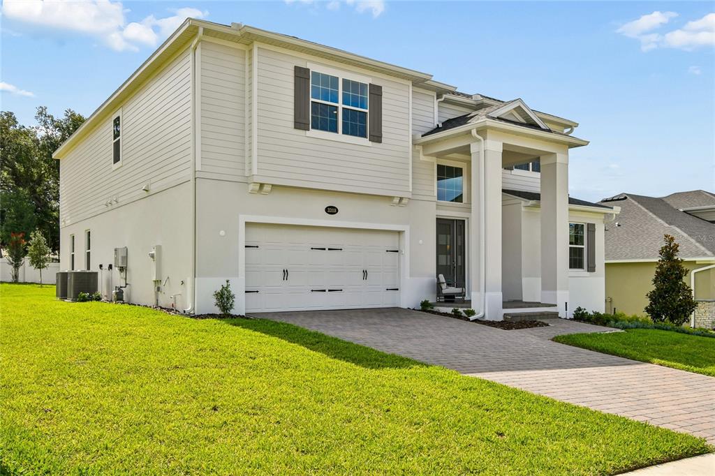 A two-story house with light-colored siding, a two-car garage, and a paved driveway — 3318 WOLF LAKE AVENUE, APOPKA, FL