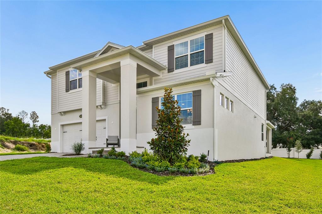 A two-story house with a light-colored exterior, a front porch, and a small lawn — 3318 WOLF LAKE AVENUE, APOPKA, FL