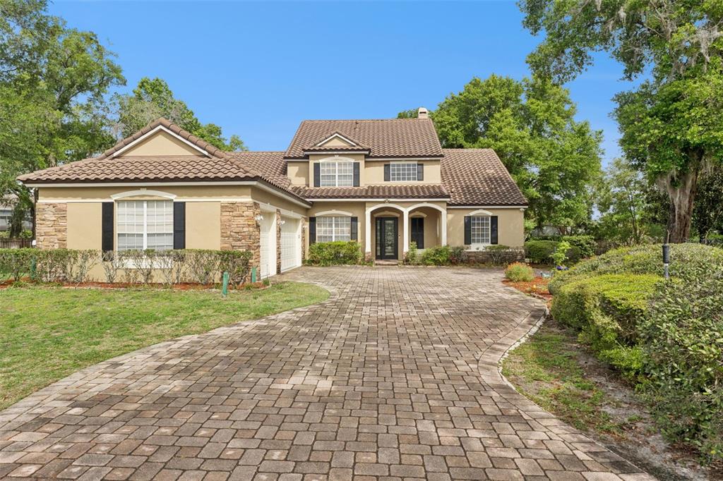 A two-story house with a tiled roof and a paved driveway sits on a landscaped lot — 216 JUNIPER RIDGE COURT, SANFORD, FL