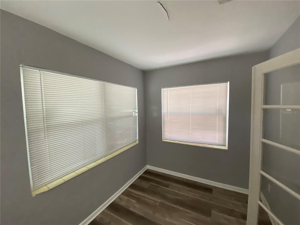 A small room with gray walls, wood-look flooring, and two windows with white blinds — 1851 50TH AVENUE N, ST PETERSBURG, FL