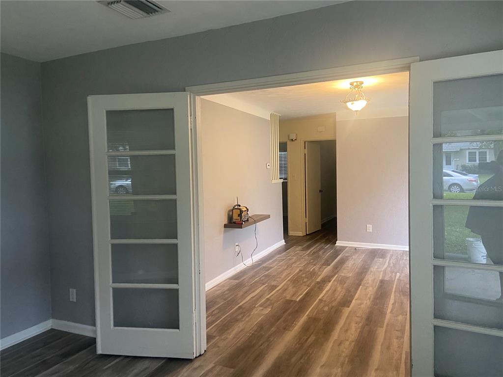 A view through French doors into a room with wood-look flooring and gray walls — 1851 50TH AVENUE N, ST PETERSBURG, FL