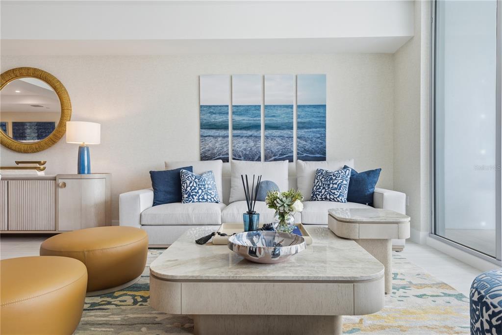 A living room features a white sofa, a marble coffee table, and coastal-themed wall art — 5713 BOWEN DANIEL DR. UNIT 1603, TAMPA, FL
