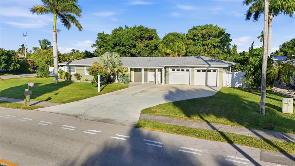 A single-story house with a two-car garage, a concrete driveway, and palm trees — 5229 PELICAN BOULEVARD, CAPE CORAL, FL