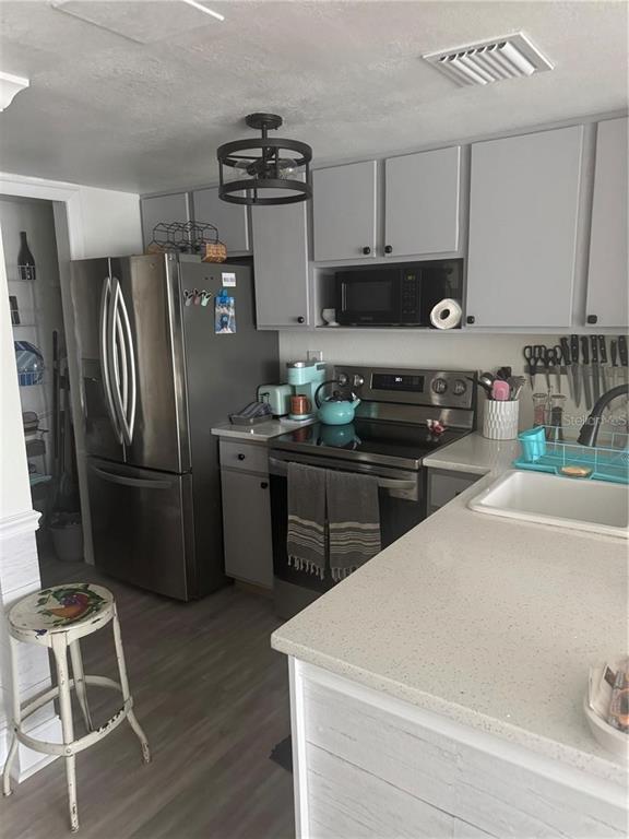 A kitchen features gray cabinets, stainless steel appliances, and a light-colored quartz countertop — 550 ORANGE DRIVE UNIT 3, ALTAMONTE SPRINGS, FL