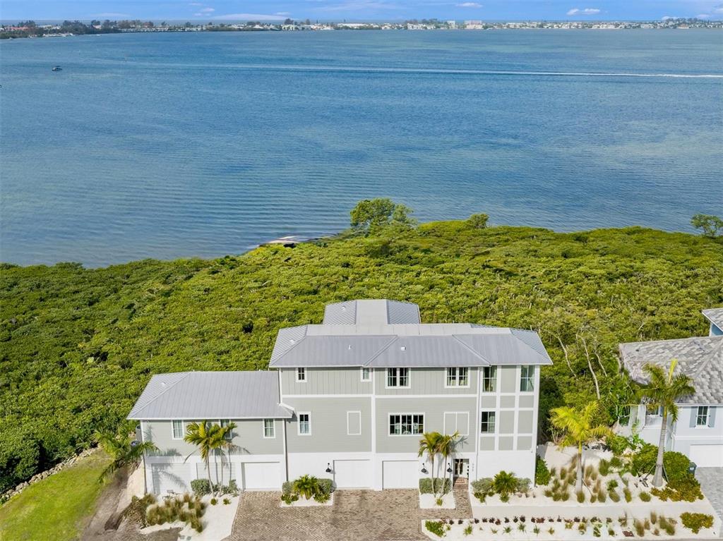An aerial view of a multi-story house with a metal roof near the water — 332 HARBOUR SOUND COURT, BRADENTON, FL