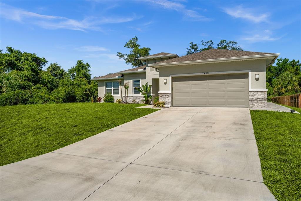 A single-story house with a beige exterior, stone accents, and a two-car garage — 4831 OCALA TERRACE, NORTH PORT, FL