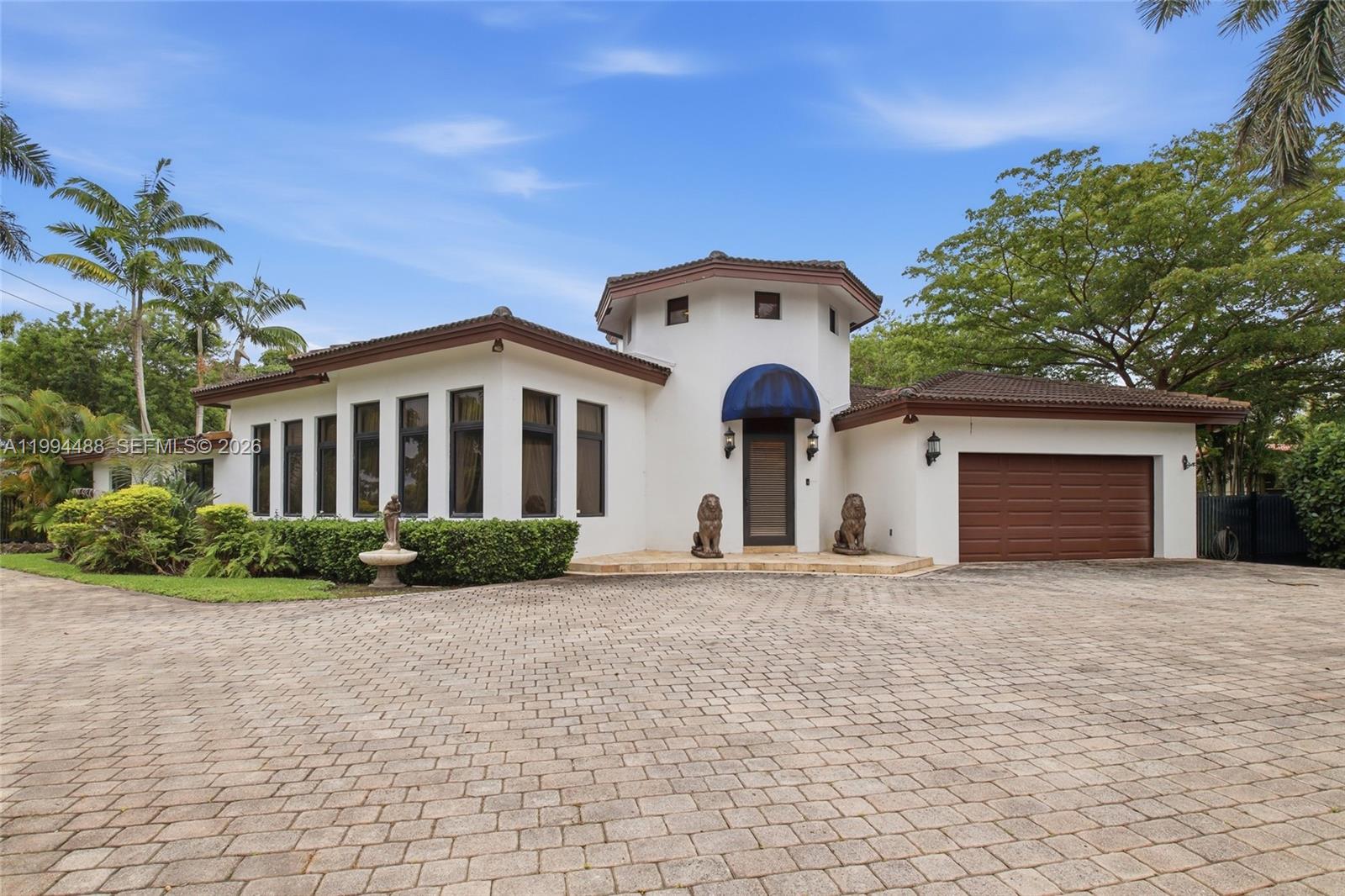 A white house with a turret entrance, lion statues, and a paved driveway — 6200 SW 97th Ave, Miami FL 33173, MIAMI, FL