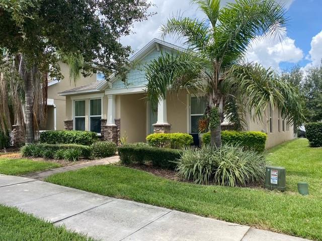 A single-story house with a palm tree, manicured hedges, and a concrete walkway in front — 15115 Pigeon Plum Lane, FL 34787, FL